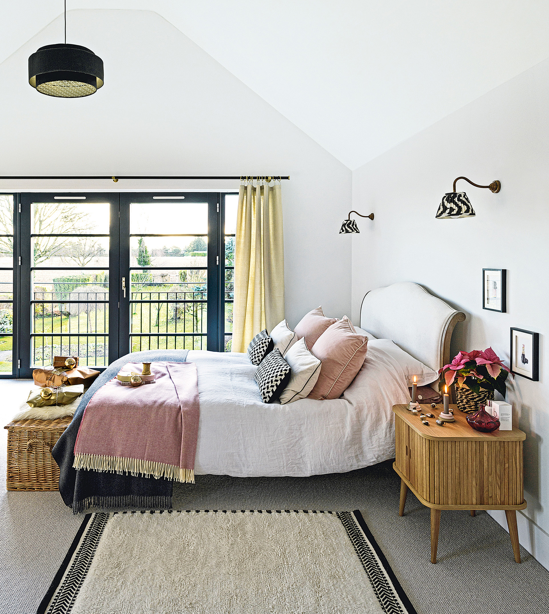 double bed with pink throw in room with white walls and juliet balcony