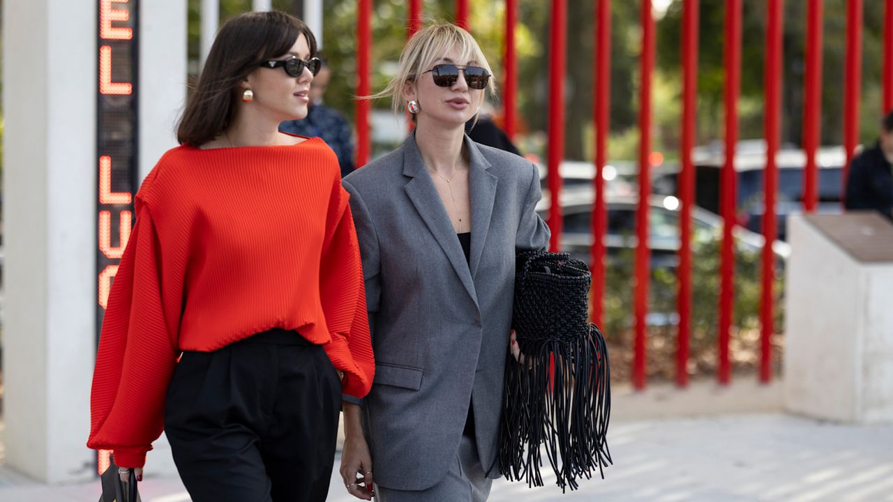 fashion week attendees wearing a red sweater black trousers sunglasses and grey suit