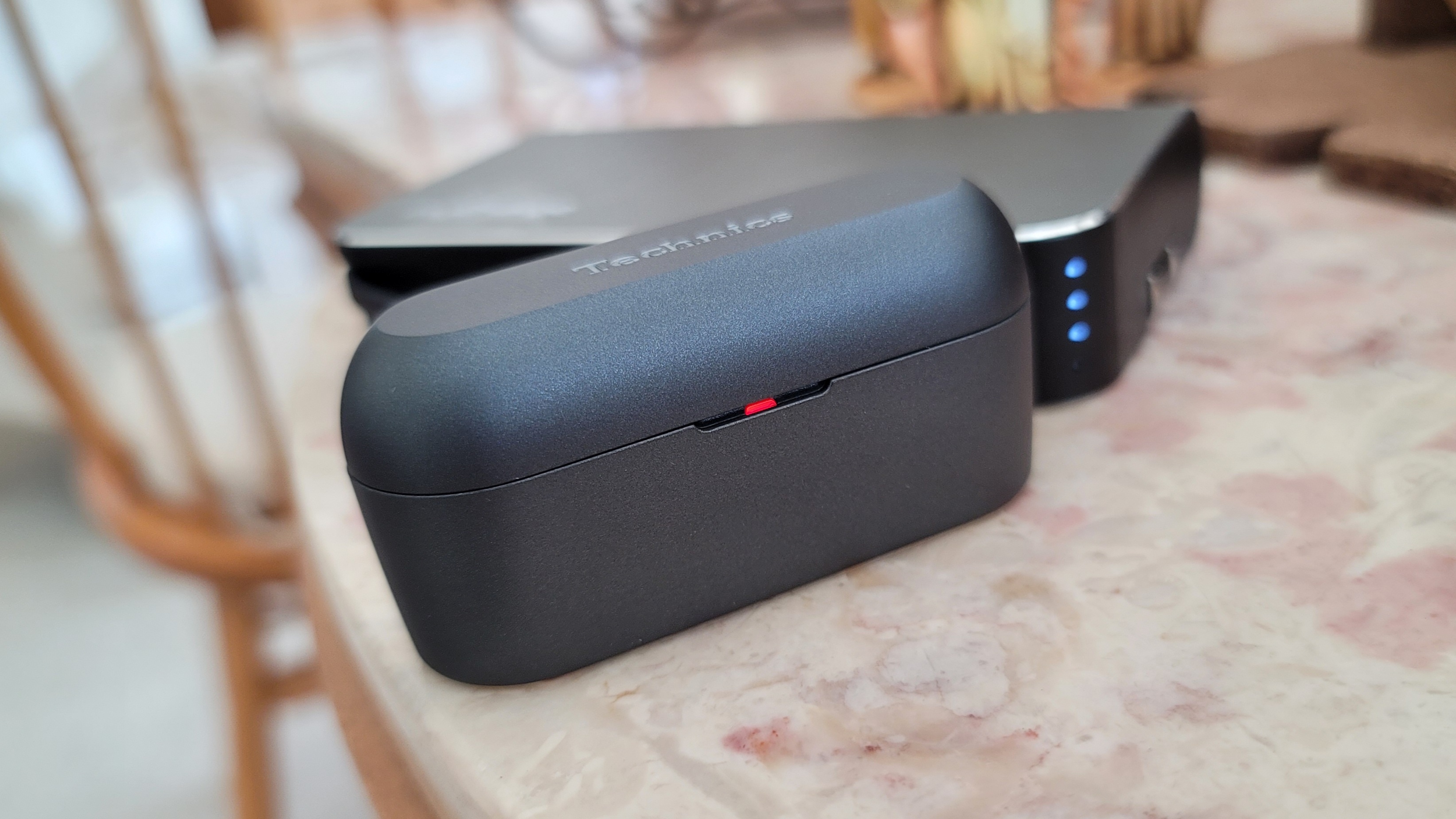 The Technics EAH-AZ60 charging case connected to a portable charger