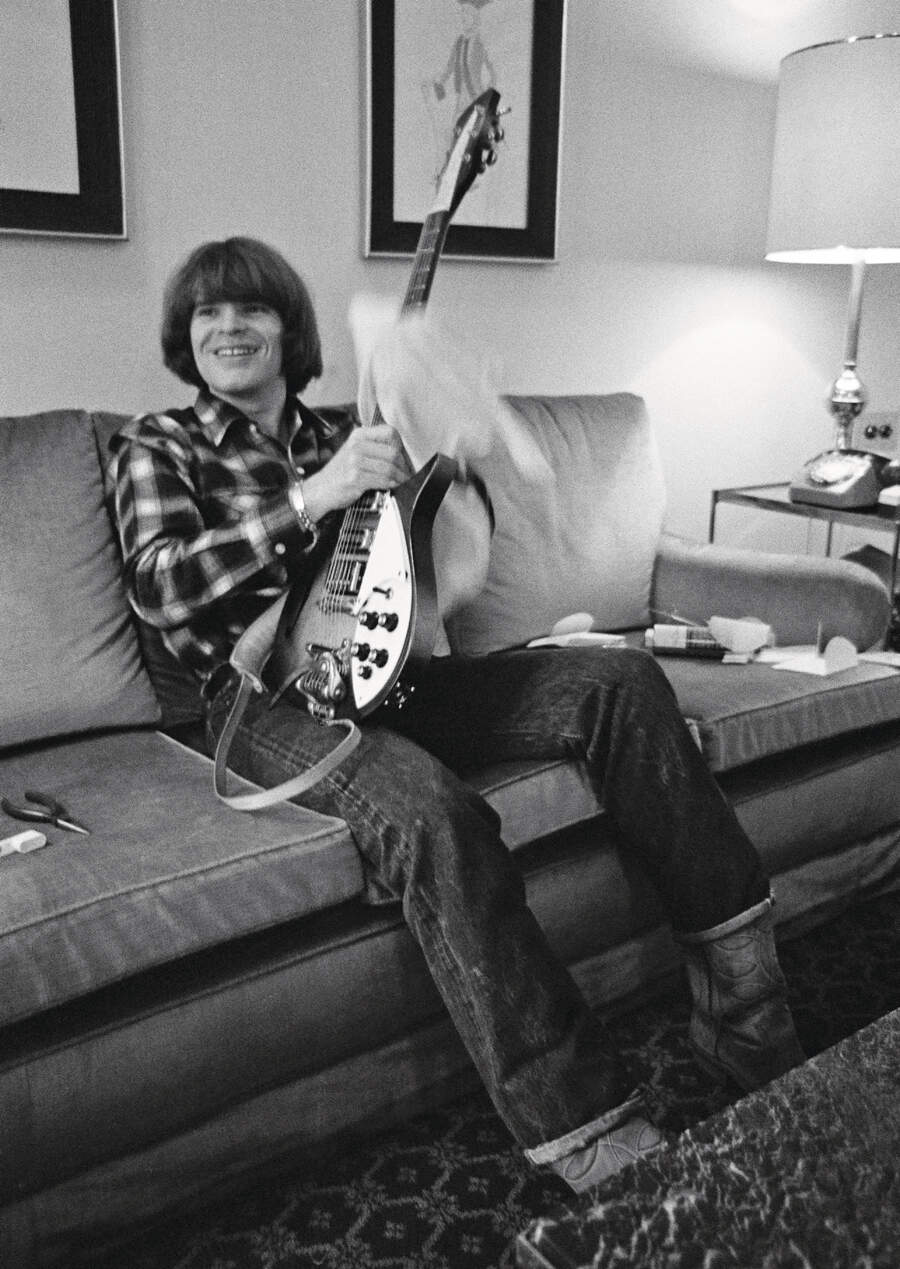 John Fogerty on a backstage sofa cleaning his Rickenbacker guitar