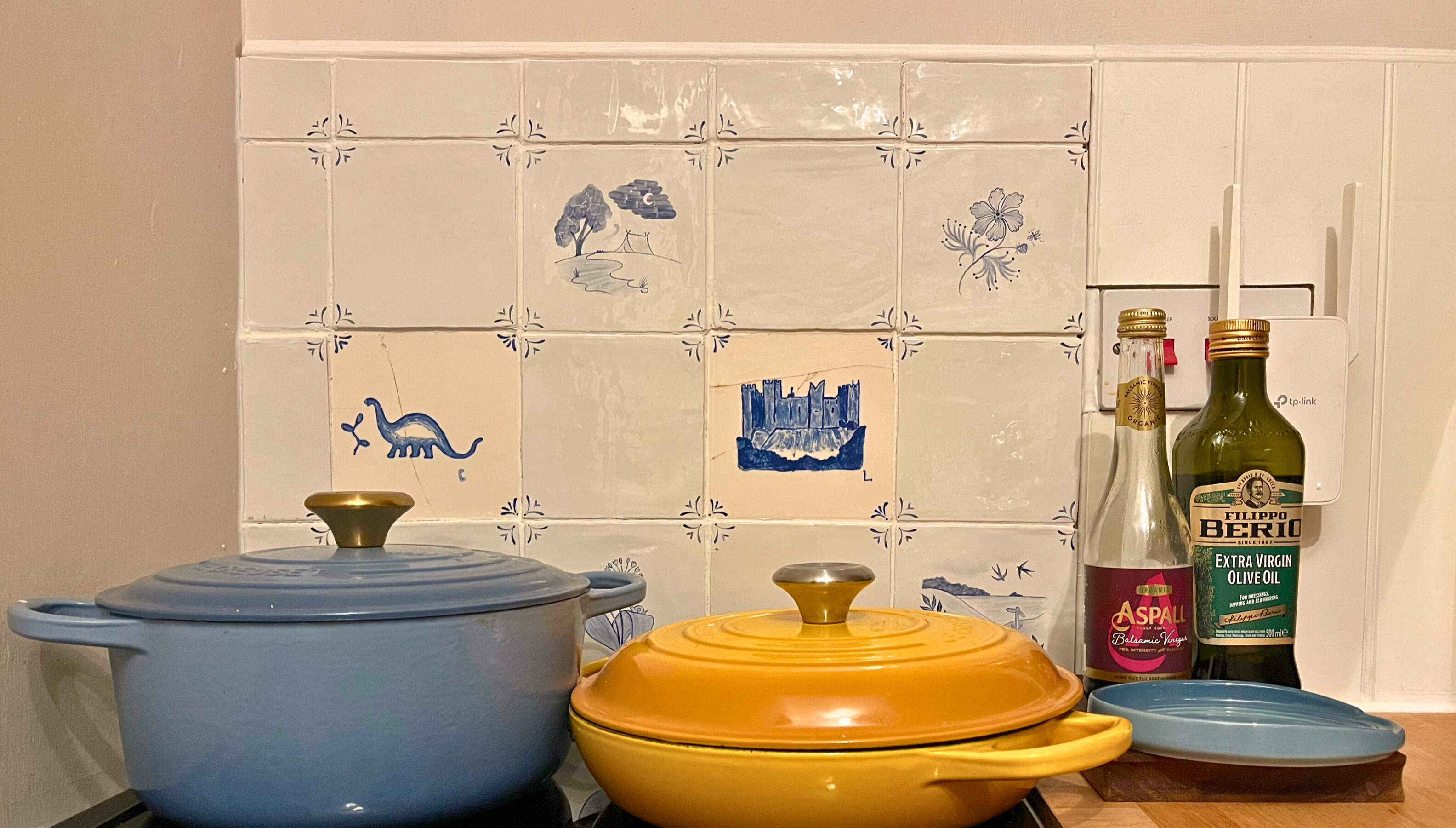 A small tiled backsplash featuring Delft tiles