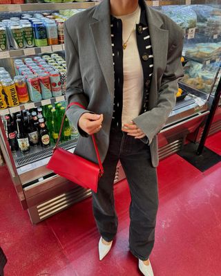 woman wearing grey blazer and baggy jeans with stiletto heels