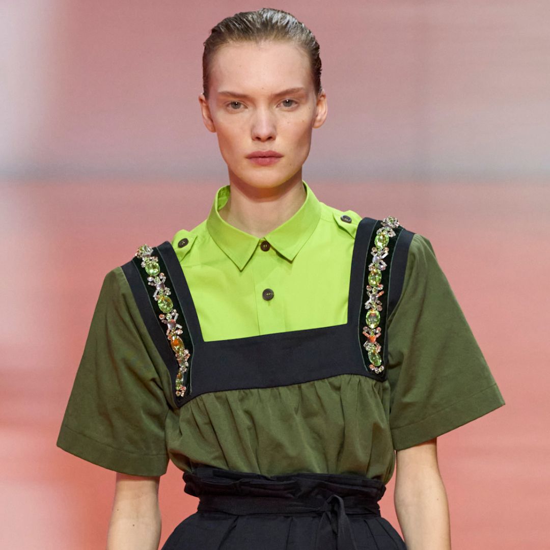 a model on the prada runway wearing an apron neckline jeweled collar