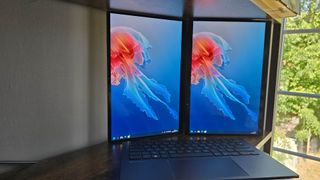 The Asus Zenbook Duo laptop photographed on a wooden desk.