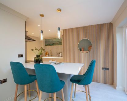 Lighting design in the kitchen with table and blue upholstered chairs