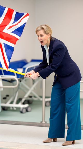 Sophie, Duchess of Edinburgh waves a Union Jack flag to start a race during a visit to Treloar's School and College