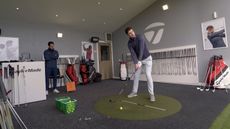A golfer lining up to hit a shot at a TaylorMade club fitting