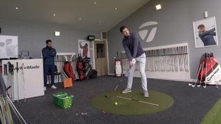 A golfer lining up to hit a shot at a TaylorMade club fitting