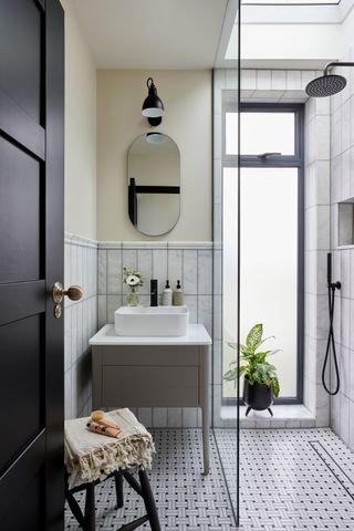 a bathroom with a black and white shower floor tile