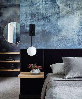 textured blue walls in modern bedroom with black wall light