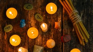 Samhain 2022: Objects for divination, runes and candle on a wooden background