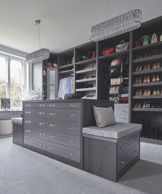 Walk-in wardrobe ideas with gray wooden storage and pale gray rugs.a