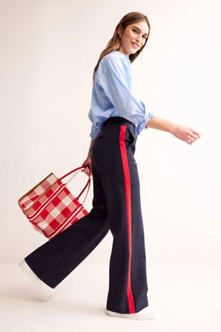 woman wearing navy trousers with a red stripe down the side