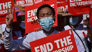 Myanmar citizens took to the streets to protest against the military coup, carrying red placards that reads 'end the dictatorship'
