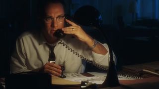Tom Hanks answers the phone in his dark office in Catch Me If You Can