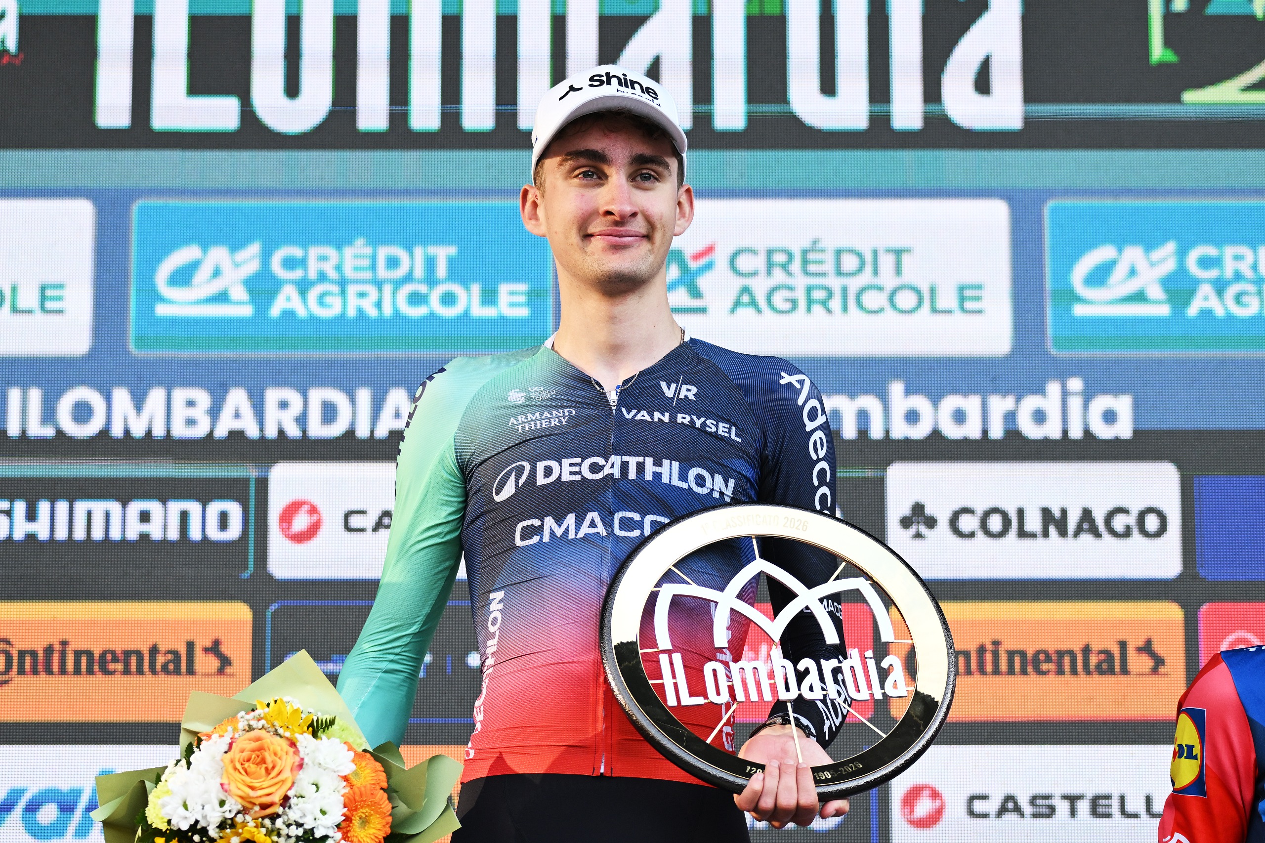 Paul Seixas celebrates Il Lombardia 2026 victory on the race's final podium with the race trophy