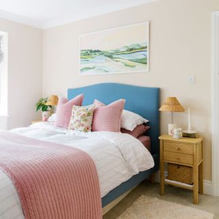 Beige bedroom with a blue bed and white bed sheets