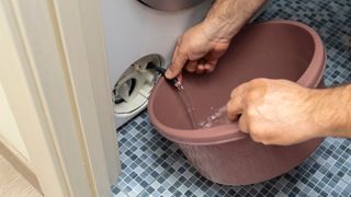 The filter of the washing machine is clogged. Plumber repairs washing machine