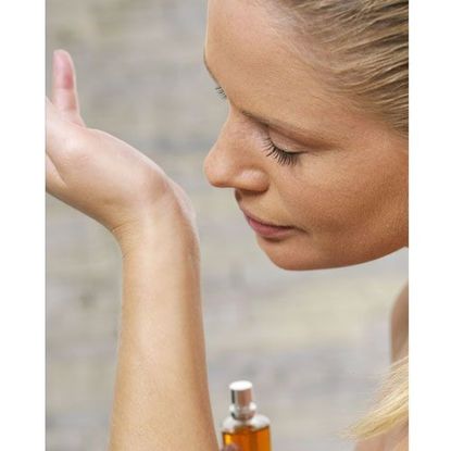 Woman Smelling Perfume on Wrist