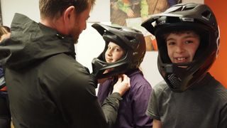 Young riders wearing full-face helmets