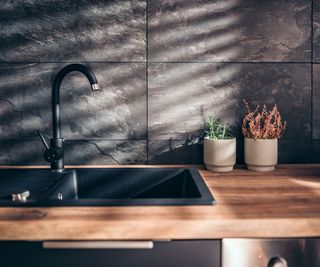 A black sink set into a wooden countertop