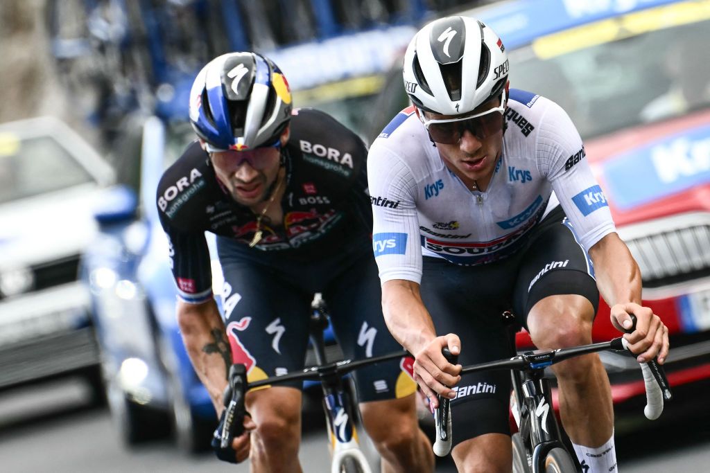 Soudal Quick-Step team&#039;s Belgian rider Remco Evenepoel wearing the best young rider&#039;s white jersey (R) and Red Bull - BORA - hansgrohe team&#039;s Slovenian rider Primoz Roglic cycle in the final kilometers of the 11th stage of the 111th edition of the Tour de France cycling race, 211 km between Ã‰vaux-les-Bains and Le Lioran, in the Massif Central mountains of central France, on July 10, 2024. (Photo by Marco BERTORELLO / AFP)