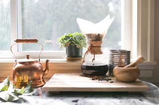 pour over coffee on kitchen counter with succulents and bronze tea kettle