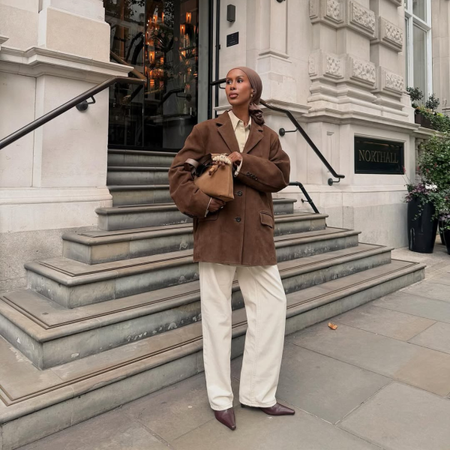 Influencer Basma K wearing cream jeans, suede jacket and pointed boots.