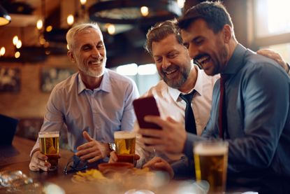 Investment club concept of men in pub discussing stocks