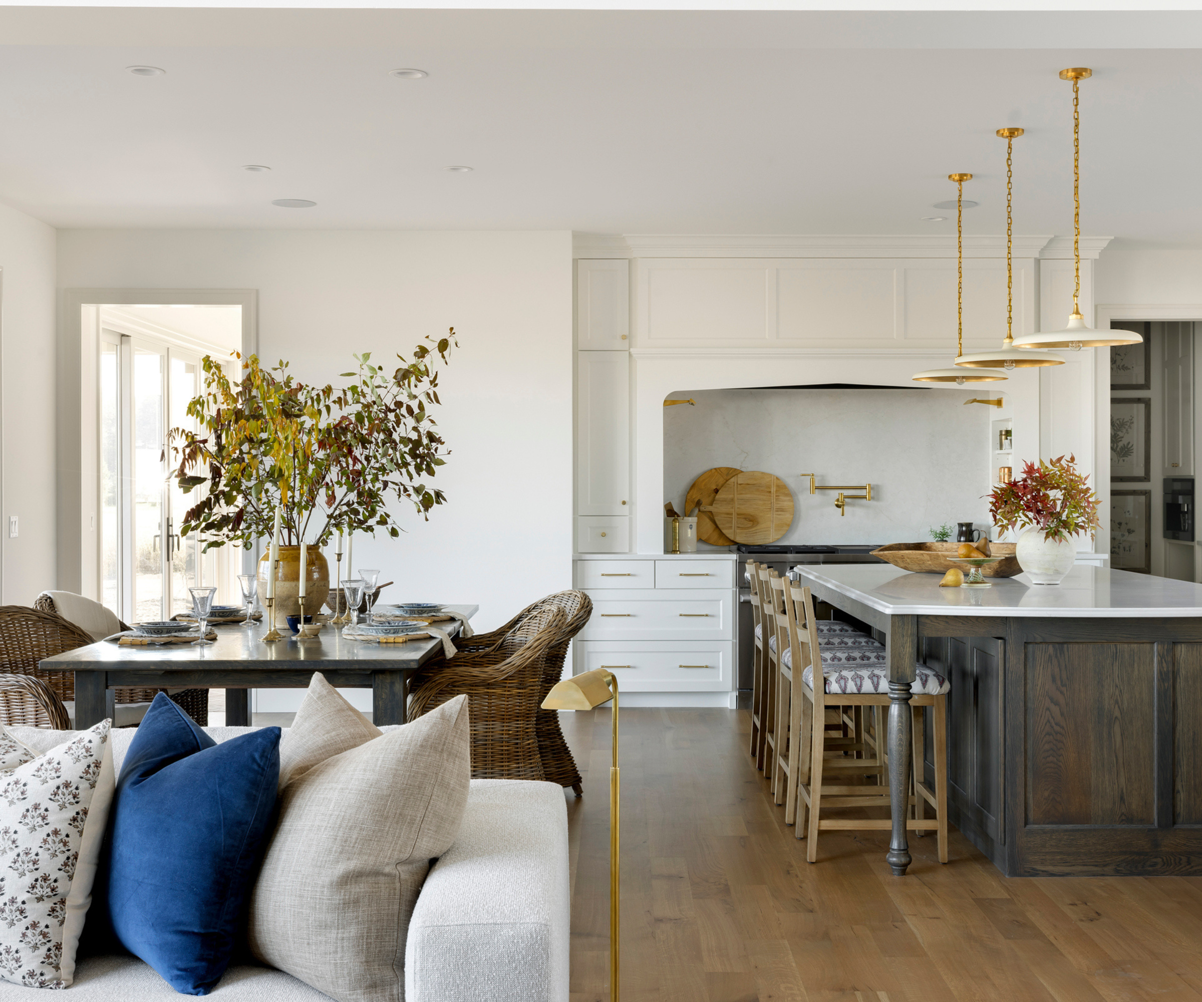 an open concept kitchen, living room, and dining room with a neutral color scheme and brass accent decor