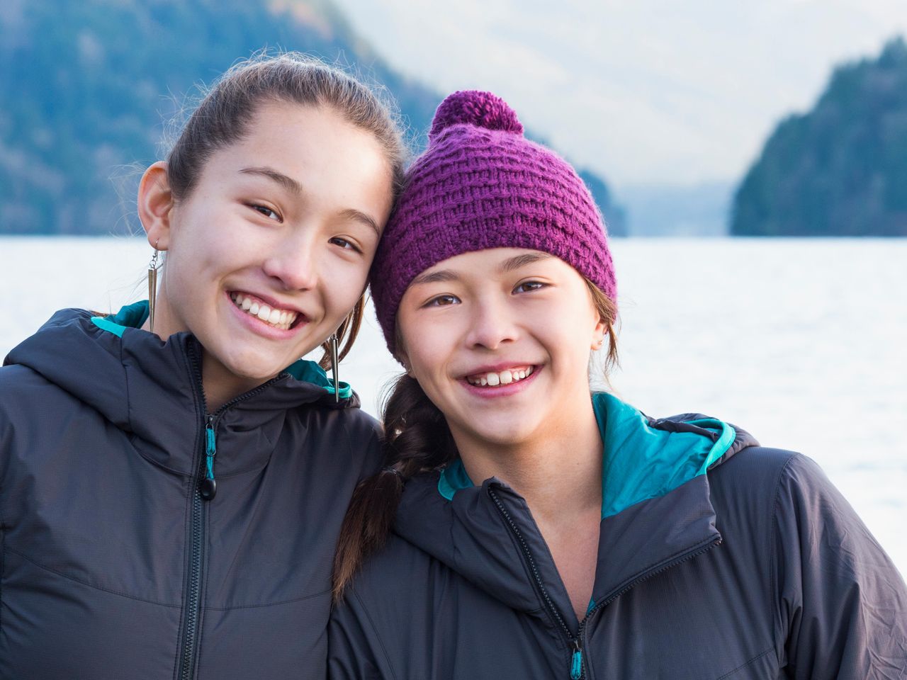 Two sisters wearing hats and smiling 