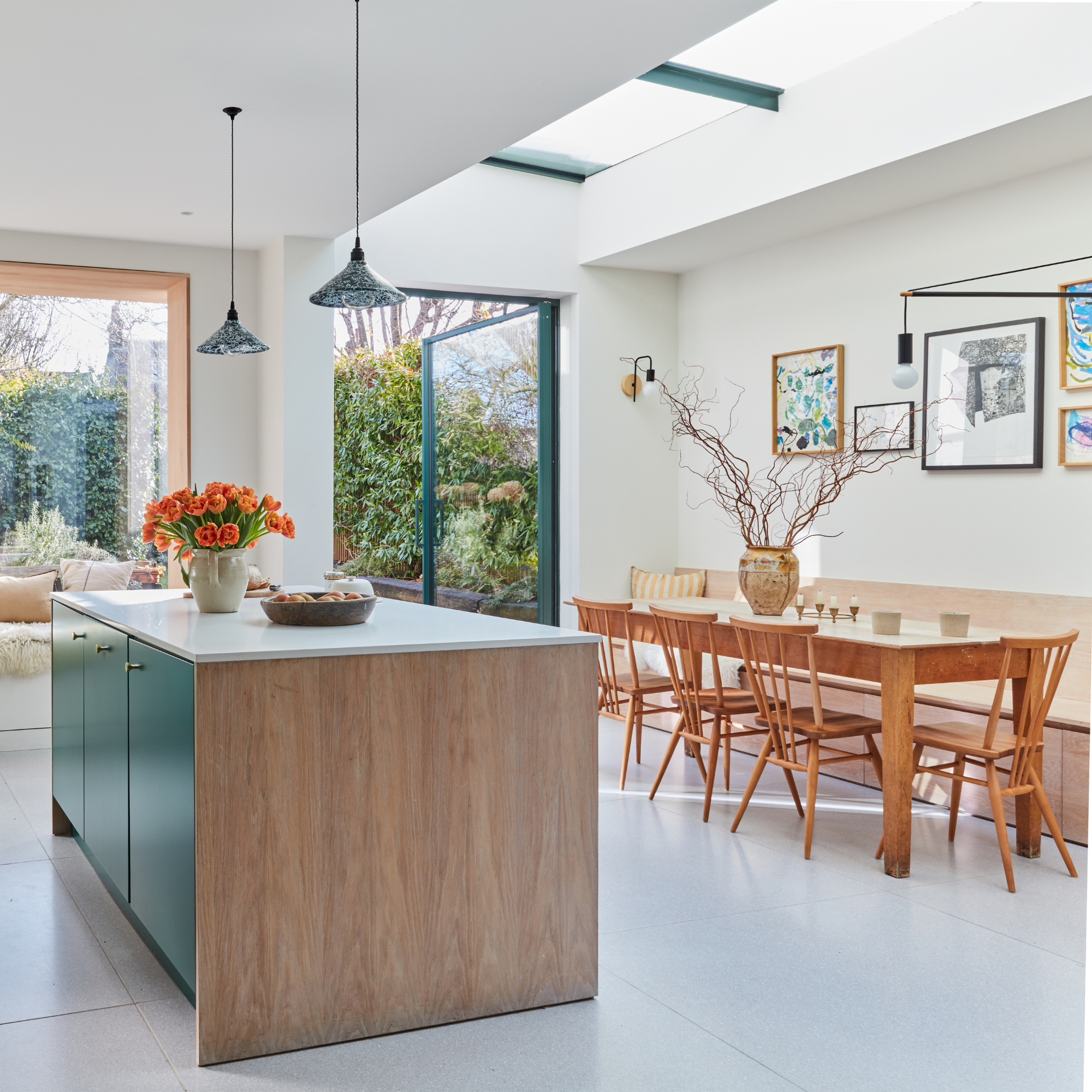 Open plan kitchen and diner with blue cabinets and a wooden table and chairs