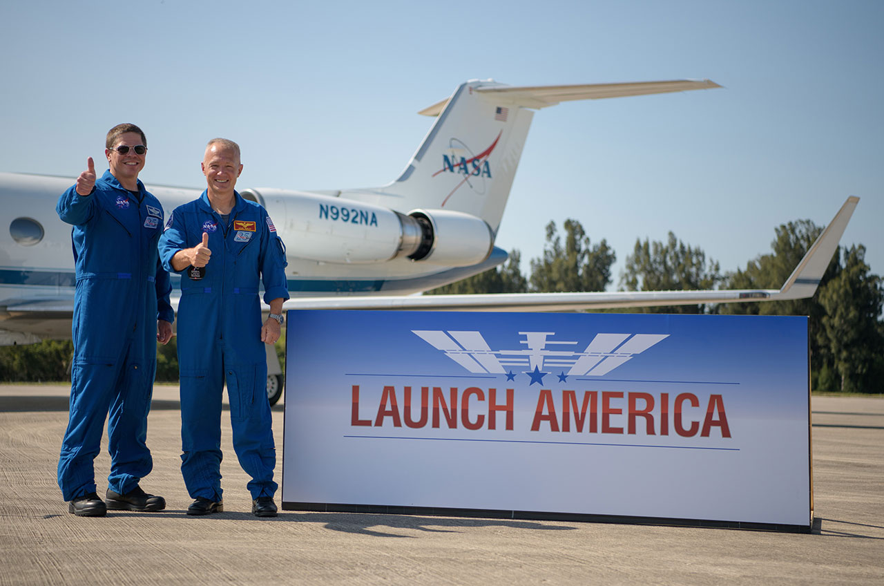 NASA astronauts Bob Behnken (at left) and Doug Hurley give a thumbs up after arriving at the Launch and Landing Facility at NASA's Kennedy Space Center in Florida ahead of launching on SpaceX's Demo-2 mission, May 20, 2020.