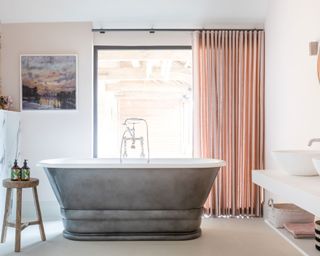 Neutral bathroom with freestanding tub in luxurious Cotswolds barn