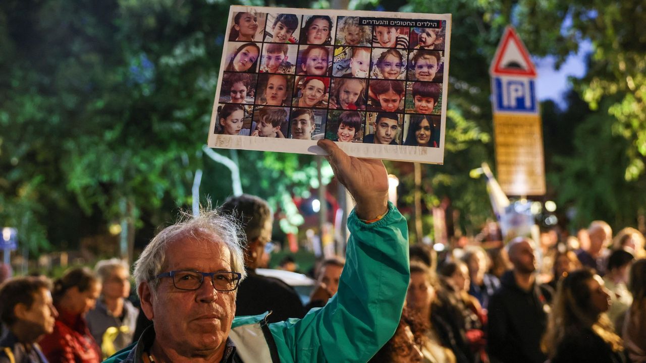 A man holds a sign with Israeli hostages