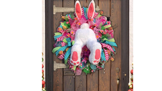 A door decoration featuring bunny legs sticking out of an Easter wreath - one of this year's best Easter decorations