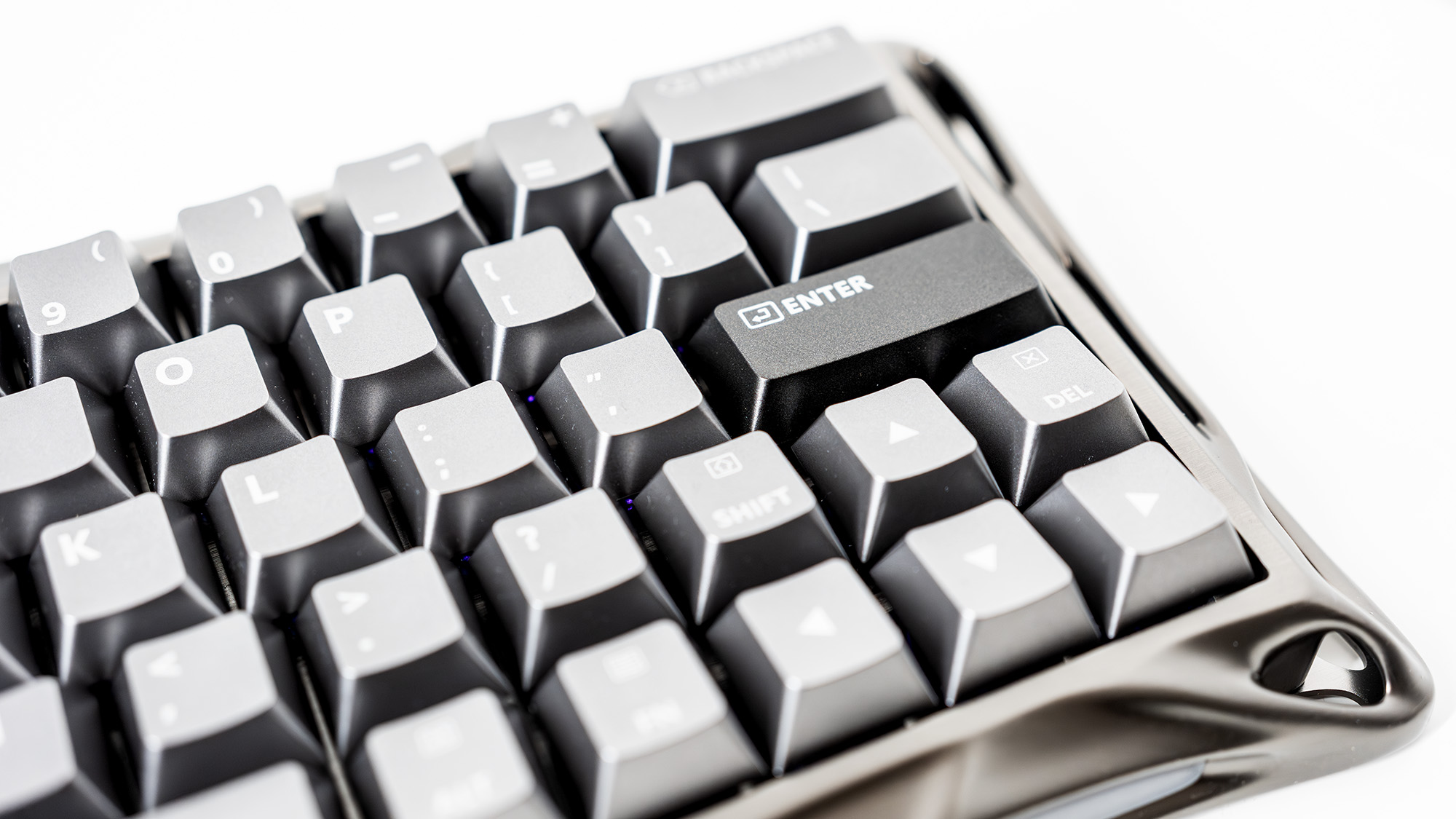 A Gravastar Mercury V60 Pro gaming keyboard with a shiny aluminium shell on a white desk.