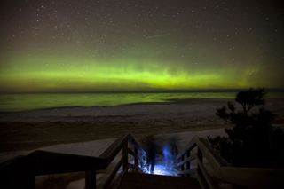 Astrophotographer Shawn Malone took this image of an aurora Feb. 18, 2012. She said: "A couple and their dog make their way down the beach stairs to check out the aurora borealis, over Lake Superior, Marquette MI. Can only wonder what the view must have been like from the passing plane pictured as a streak middle frame."