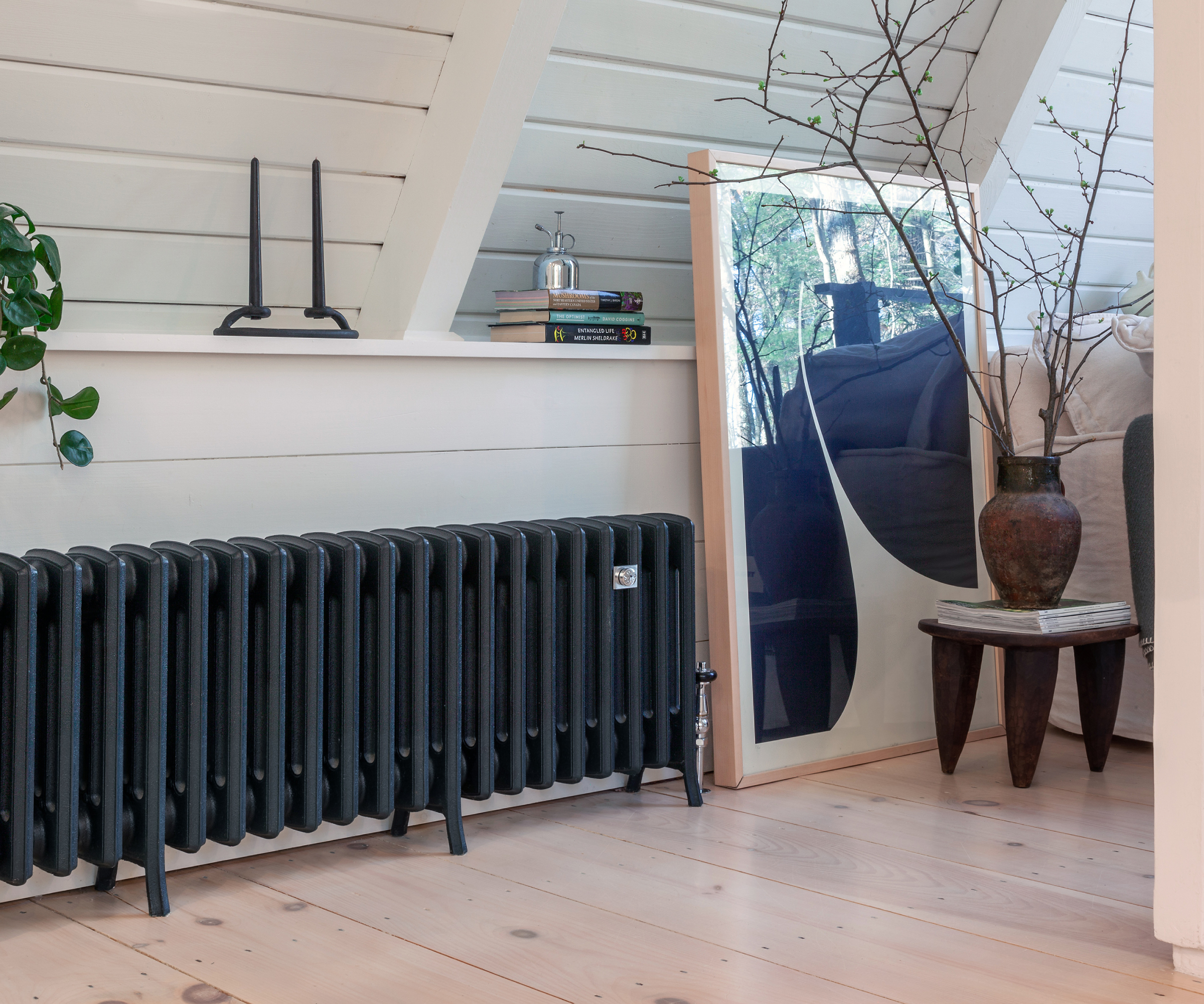 long low level navy radiator below sloped ceiling