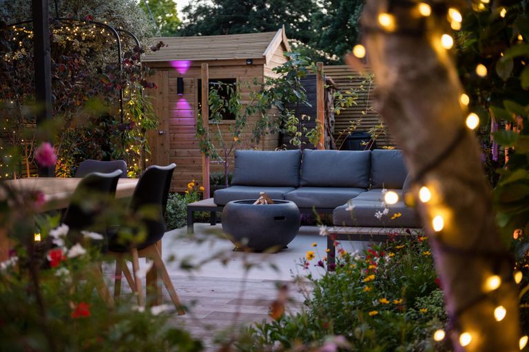 a deck with a sofa and lighting turned on