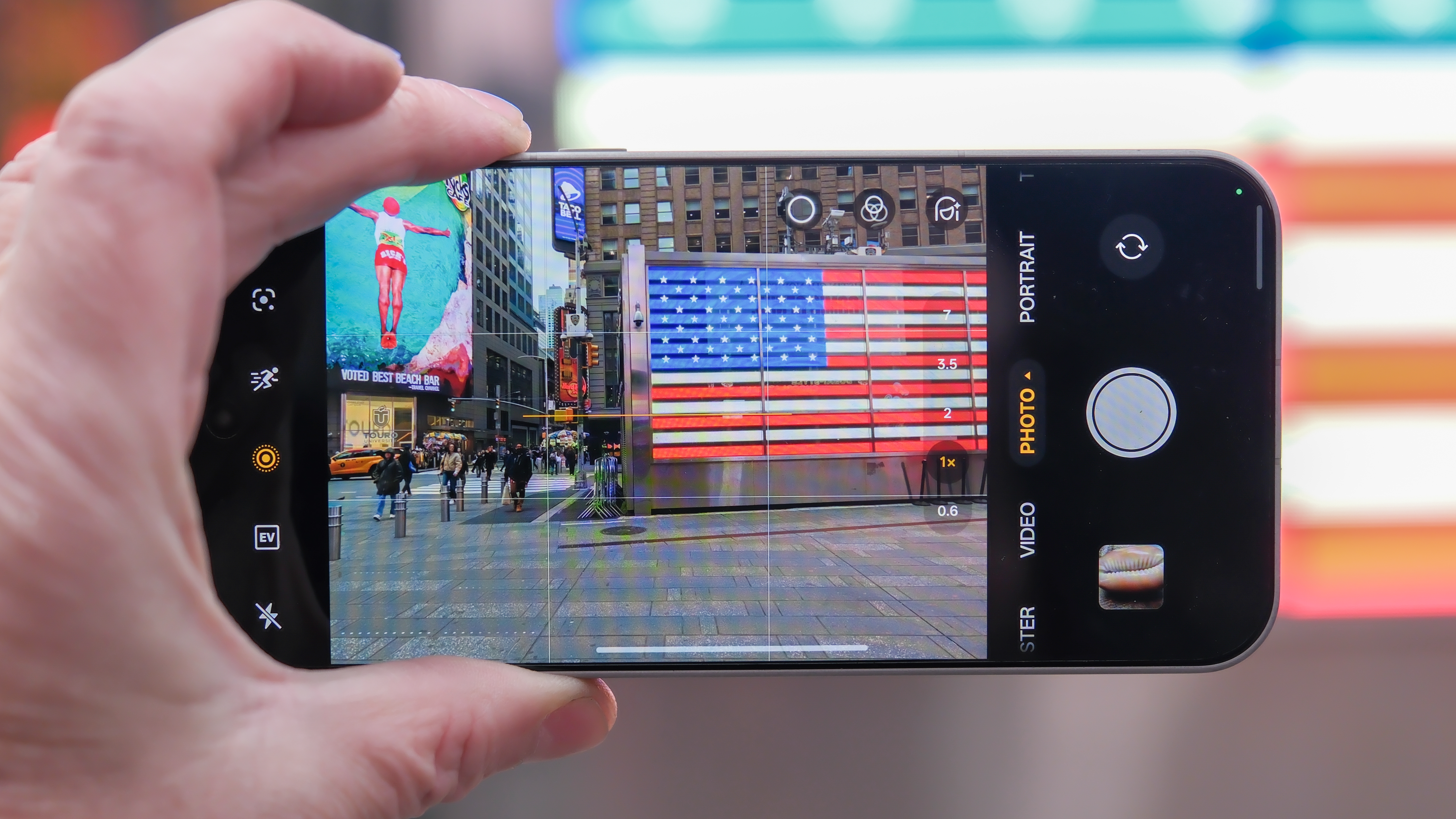 OnePlus 15 in Times Square New York City on the busy street showing the cameras and sides of the phone in addition to home screen panels and Settings menus