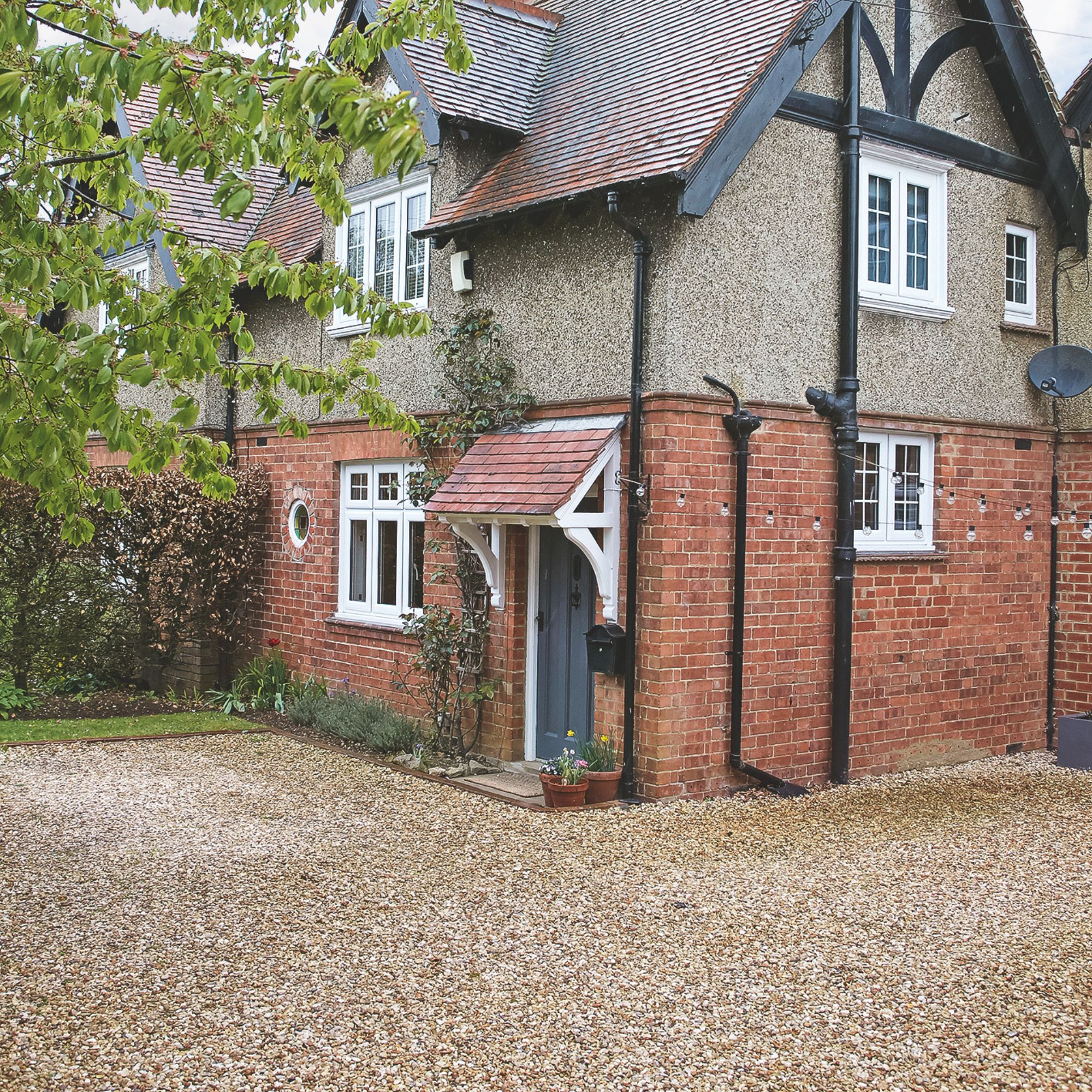 Brick and pebble dash house with canopy porch and gravel driveway