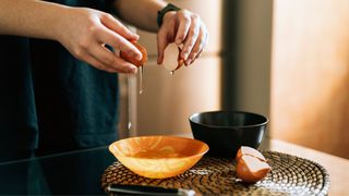 Woman's hands cracking egg into bowl