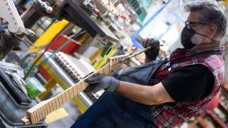 A builder check the truss rod used to adjust the neck of a guitar at the Fender factory, in Corona, California, on October 6, 2022