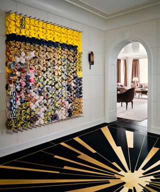 entry with Art Deco inspired black and gold sunburst terrazzo floor and statement artwork