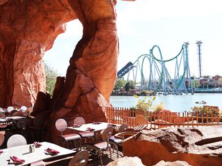 Mythos outdoor seating with a view of the Hulk roller coaster