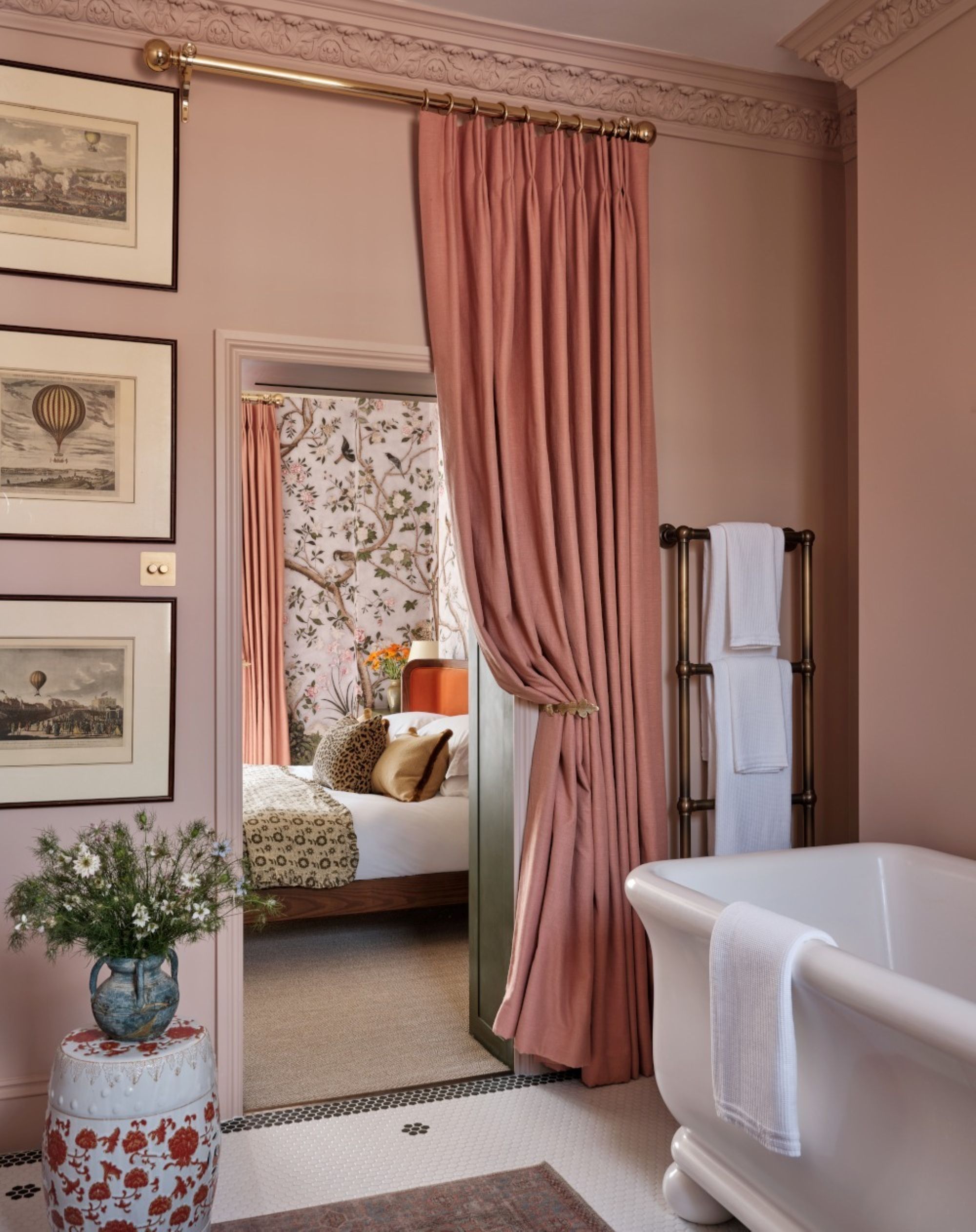 a bathroom with light pink paint an a pink curtain to separate the bedroom from the bathroom