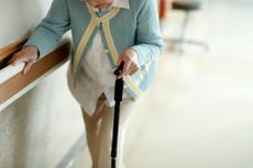 Senior woman walking with walking stick