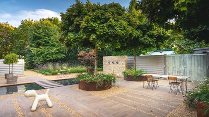 south-facing garden ideas showing paved patio, gravel paths and a water feature