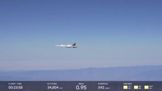 a small white jet flies high above desert mountains